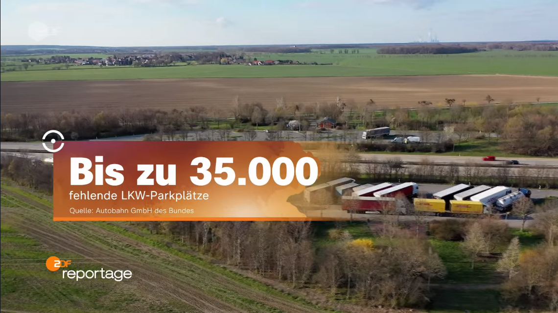 Banner mit der Aufschrift 'Bis zu 35000 fehlende LKW-Parkplätze' über der sächsischen Landschaft